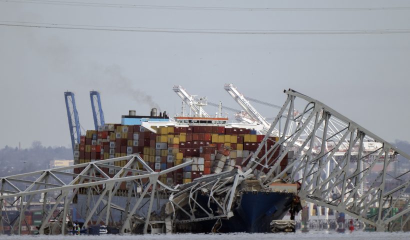 A container ship rests against wreckage of the Francis Scott Key Bridge on Tuesday, March 26, 2024, as seen from Pasadena, Md. The ship rammed into the major bridge in Baltimore early Tuesday, causing it to collapse in a matter of seconds and creating a terrifying scene as several vehicles plunged into the chilly river below. (AP Photo/Mark Schiefelbein)