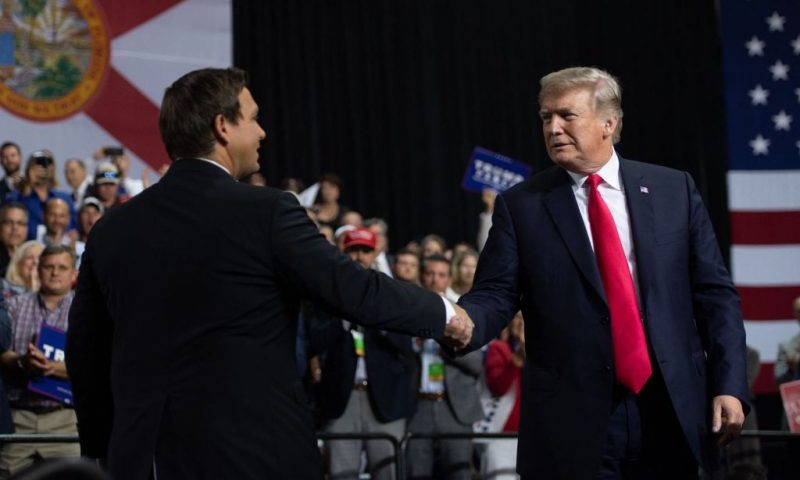 US President Donald Trump shakes hands with US Representative Ron DeSantis, Republican of Florida, and candidate for Florida Governor, as he speaks during a campaign rally at Florida State Fairgrounds Expo Hall in Tampa, Florida, on July 31, 2018. (Photo by SAUL LOEB / AFP) (Photo by SAUL LOEB/AFP via Getty Images)