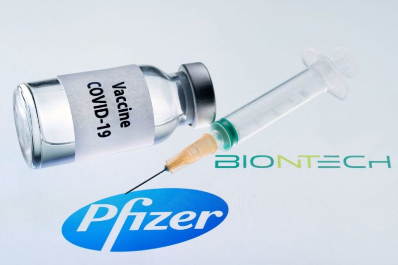 This illustration picture taken on November 23, 2020 shows a bottle reading "Vaccine Covid-19" and a syringe next to the Pfizer and Biontech logo. - The European Commission has signed five contracts to pre-order vaccines, among which with the U.S.-German company Pfizer-BioNTech (up to 300 million doses). (Photo by JOEL SAGET / AFP) (Photo by JOEL SAGET/AFP via Getty Images)