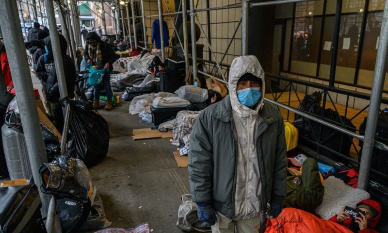 Migrants camp outside a hotel where they had previously been housed, as they resist efforts by the city to relocate them to a Brooklyn facility for asylum seekers, in the Hells Kitchen neighborhood of New York on January 31, 2023. - The Brooklyn facility is the city's fifth relief center amid a continued influx of asylum seekers, according to local media. (Photo by Ed JONES / AFP) (Photo by ED JONES/AFP via Getty Images)