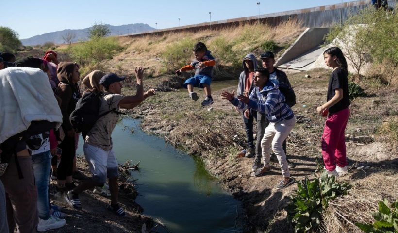 TOPSHOT - Migrants cross the Bravo river seen from the Mexican side of the US-Mexico border in Ciudad Juarez, Chihuahua state, Mexico, on March 29, 2023. - About 200,000 people try to cross the border from Mexico into the United States each month, most of them fleeing poverty and violence in Central and South America. (Photo by Guillermo Arias / AFP) (Photo by GUILLERMO ARIAS/AFP via Getty Images)