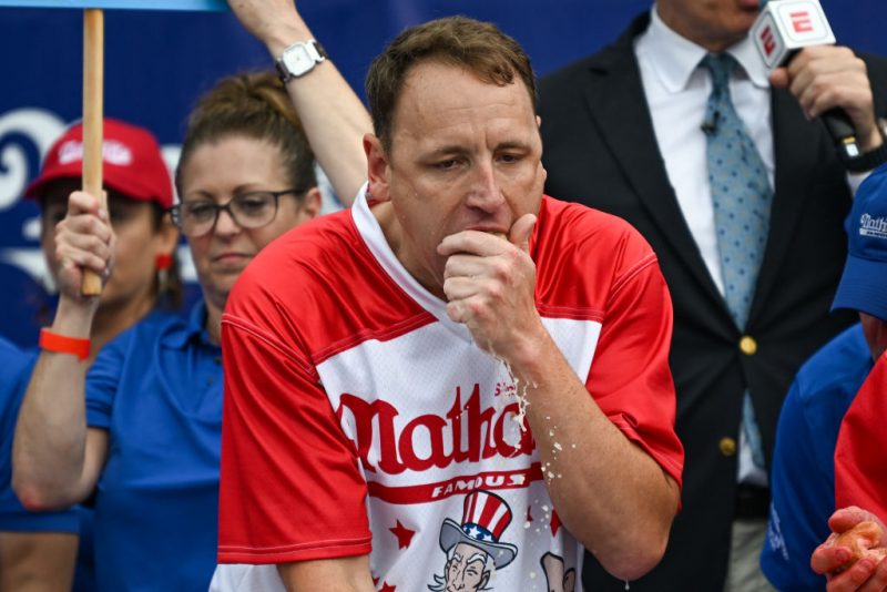 NEW YORK, NEW YORK - JULY 04: Defending champion Joey Chestnut competes in the 2023 Nathan's Famous Fourth of July International Hot Dog Eating Contest on July 4, 2023 at Coney Island in the Brooklyn borough of New York City. The men's contest was postponed due to thunderstorms but later happened without spectators allowed into the "arena." The annual contest, which began in 1972, draws thousands of spectators to Nathan’s Famous located on Surf Avenue. (Photo by Alexi J. Rosenfeld/Getty Images)