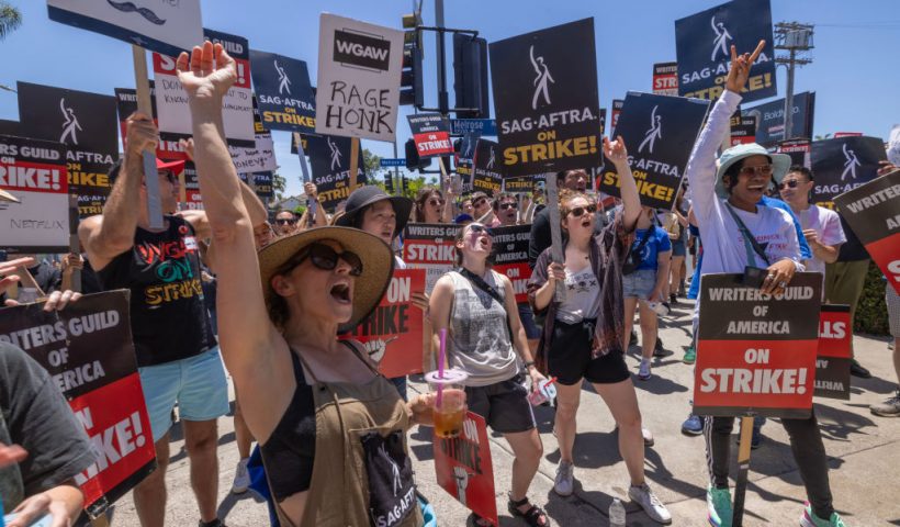 LOS ANGELES, CALIFORNIA - JULY 14: Members of the Hollywood actors SAG-AFTRA union walk a picket line with screenwriters outside of Paramount Studios on Day 2 of the actors' strike on July 14, 2023 in Los Angeles, California. Members of SAG-AFTRA, Hollywood’s largest union which represents actors and other media professionals, joined striking WGA (Writers Guild of America) workers in the first joint walkout against the studios since 1960. The strike could shut down Hollywood productions completely with writers in the third month of their strike against the Hollywood studios. (Photo by David McNew/Getty Images)