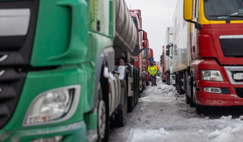 Ukrainian truck drivers are seen next to Ukrainian trucks on the parking lot near Korczowa Polish-Ukrainian border crossing, on December 5, 2023. In a Polish car park near the Ukrainian border, truck drivers stranded by a month-long blockade that has caused disruption and a row with Ukraine shoveled snow off their vehicles.