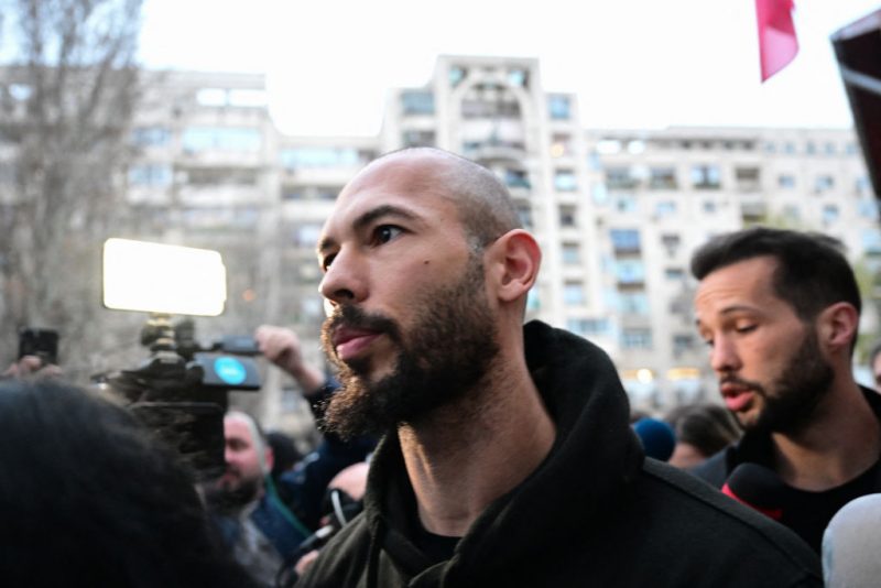 British-US former professional kickboxer and controversial influencer Andrew Tate (L) and his brother Tristan Tate (R) leave after having been released from detention in Bucharest, Romania on March 12, 2024, after they appeared in a court after Romanian police detained them over UK sex offence charges. A Bucharest court on March 12 granted a request to extradite controversial influencer Andrew Tate to the UK over sex offence charges, but only after the conclusion of legal proceedings in Romania in a separate case. The Bucharest appeals court ruling "orders the execution of the warrant of arrest issued on 19 January 2024" by the Westminster Magistrates' Court, but postpones extradition "until the final resolution of the case" in Romania, which could take years. (Photo by Daniel MIHAILESCU / AFP) (Photo by DANIEL MIHAILESCU/AFP via Getty Images)