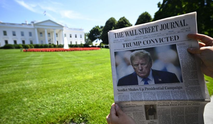 A journalist shows a 'The Wall Street Journal' newspaper with the headline reading 'Trump convicted', outside the White House in Washington DC, United States, Friday 31 May 2024.