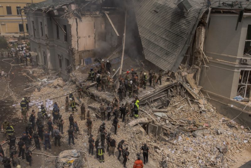 Emergency and rescue personnel along with medics and others clear the rubble of the destroyed building of Ohmatdyt Children's Hospital following a Russian missile attack in the Ukrainian capital of Kyiv on July 8, 2024, amid Russian invasion in Ukraine. Russia launched more than 40 missiles at several cities across Ukraine on July 8, 2024 in an attack that killed at least 20 people and smashed into a children's hospital in Kyiv, officials said. (Photo by Roman PILIPEY / AFP) (Photo by ROMAN PILIPEY/AFP via Getty Images)