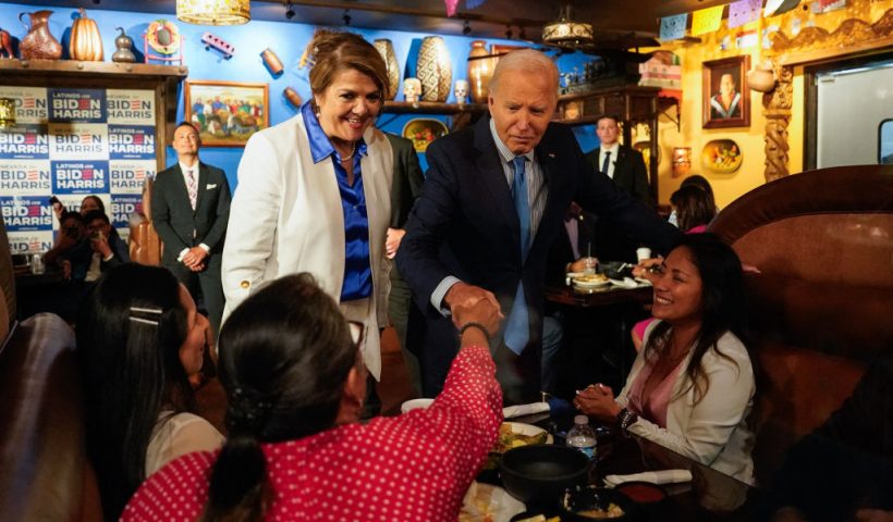 US President Joe Biden, alongside Maritza Rodriguez (in white), a campaign advisor for the Biden Nevada state team, greets people as he arrives at Lindo Michoacan restaurant ahead of a radio interview in Las Vegas, Nevada, on July 17, 2024. (Photo by Kent Nishimura / AFP) (Photo by KENT NISHIMURA/AFP via Getty Images)