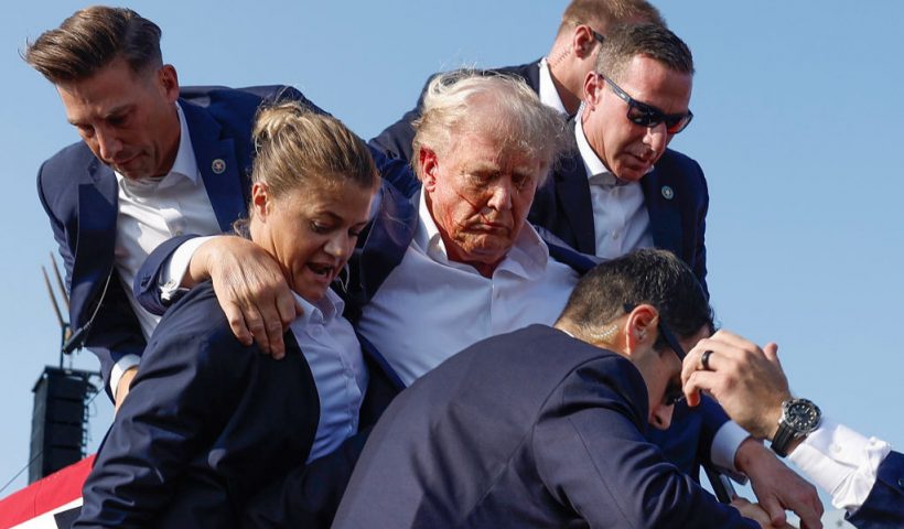 BUTLER, PENNSYLVANIA - JULY 13: Republican presidential candidate former President Donald Trump is rushed offstage by U.S. Secret Service agents after being grazed by a bullet during a rally on July 13, 2024 in Butler, Pennsylvania. Butler County district attorney Richard Goldinger said the shooter is dead after injuring former U.S. President Donald Trump, killing one audience member and injuring another in the shooting. (Photo by Anna Moneymaker/Getty Images)