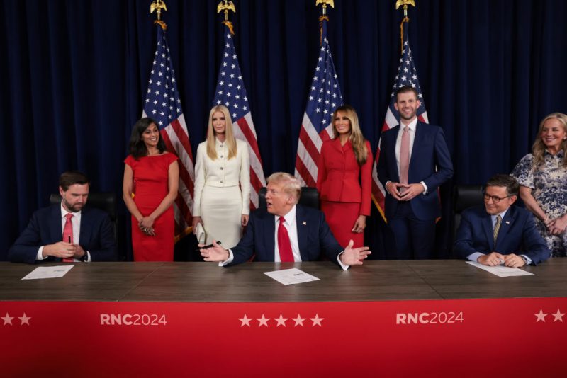 MILWAUKEE, WISCONSIN - JULY 18: Republican presidential candidate, former U.S. President Donald Trump signs a document officially accepting the Republican presidential nomination as his family looks on during the fourth day of the Republican National Convention at the Fiserv Forum on July 18, 2024 in Milwaukee, Wisconsin. Delegates, politicians, and the Republican faithful are in Milwaukee for the annual convention, concluding with former President Donald Trump accepting his party's presidential nomination. The RNC takes place from July 15-18. (Photo by Win McNamee/Getty Images)