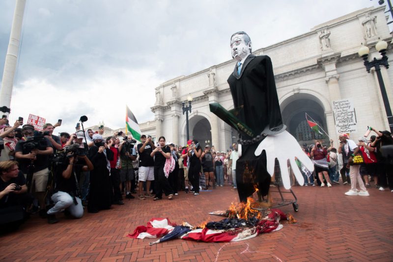 Pro-Palestinian protesters burn a US flag at Union Station on July 24, 2024 during a protest against Israeli Prime Minister Benjamin Netanyahu's visit to the US. Netanyahu slammed Gaza ceasefire demonstrators and called for a global alliance against the Iranian regime he accuses of funding them, as he addressed a US Congress divided by the war. (Photo by Matthew Hatcher / AFP) (Photo by MATTHEW HATCHER/AFP via Getty Images)