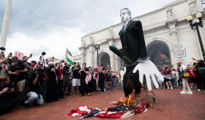 Pro-Palestinian protesters burn a US flag at Union Station on July 24, 2024 during a protest against Israeli Prime Minister Benjamin Netanyahu's visit to the US. Netanyahu slammed Gaza ceasefire demonstrators and called for a global alliance against the Iranian regime he accuses of funding them, as he addressed a US Congress divided by the war. (Photo by Matthew Hatcher / AFP) (Photo by MATTHEW HATCHER/AFP via Getty Images)