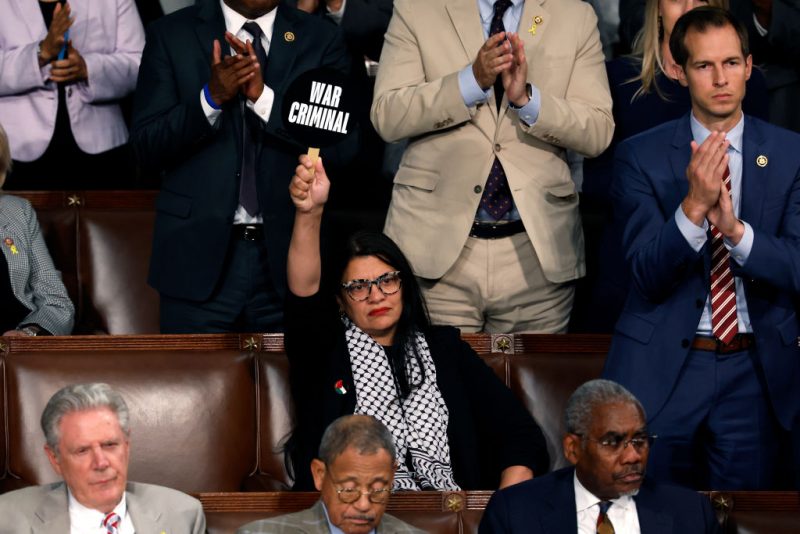 WASHINGTON, DC - JULY 24: Rep. Rashida Tlaib (D-MI) holds a sign that reads "War Criminal" as Israeli Prime Minister Benjamin Netanyahu addresses a joint meeting of Congress in the chamber of the House of Representatives at the U.S. Capitol on July 24, 2024 in Washington, DC. Netanyahu’s visit occurs as the Israel-Hamas war reaches nearly ten months. A handful of Senate and House Democrats boycotted the remarks over Israel’s treatment of Palestine. (Photo by Anna Moneymaker/Getty Images)