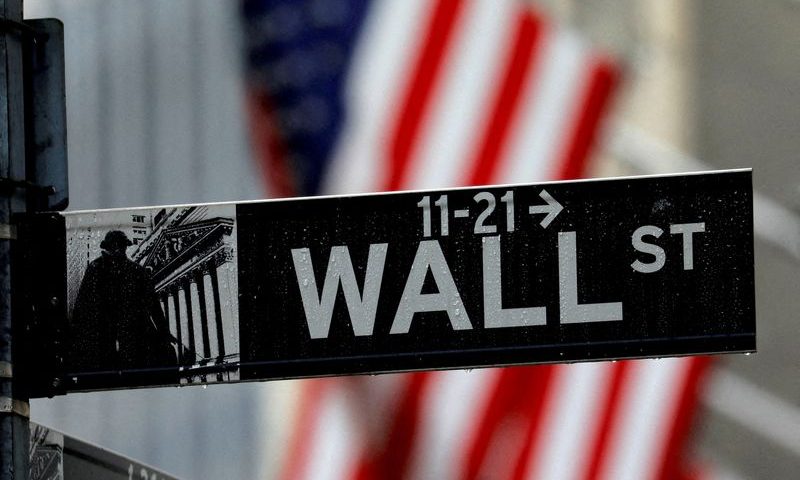 FILE PHOTO: Raindrops hang on a sign for Wall Street outside the New York Stock Exchange in New York