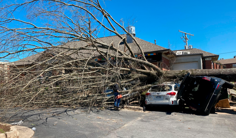 A tree tops two vehicles destroyed by Friday's tornado in Little Rock, Ark., Saturday, April 1, 2023. Unrelenting tornadoes that tore through parts of the South and Midwest that shredded homes and shopping centers. (AP Photo/Andrew DeMillo)