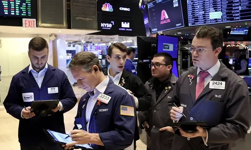 Traders gather at the post that trades Alaska Airlines stock on the floor at the New York Stock Exchange (NYSE) in New York City, U.S., December 4, 2023. REUTERS/Brendan McDermid/File Photo