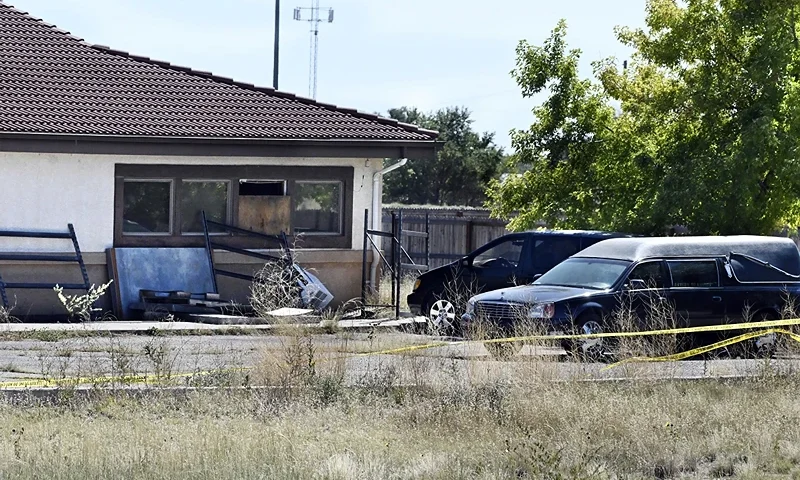 A hearse and debris can be seen at the rear of the Return to Nature Funeral Home in Penrose, Colo. Thursday, Oct. 5, 2023. Authorities said Thursday they were investigating the improper storage of human remains at a southern Colorado funeral home that performs "green" burials without embalming chemicals or metal caskets. (Jerilee Bennett/The Gazette via AP)