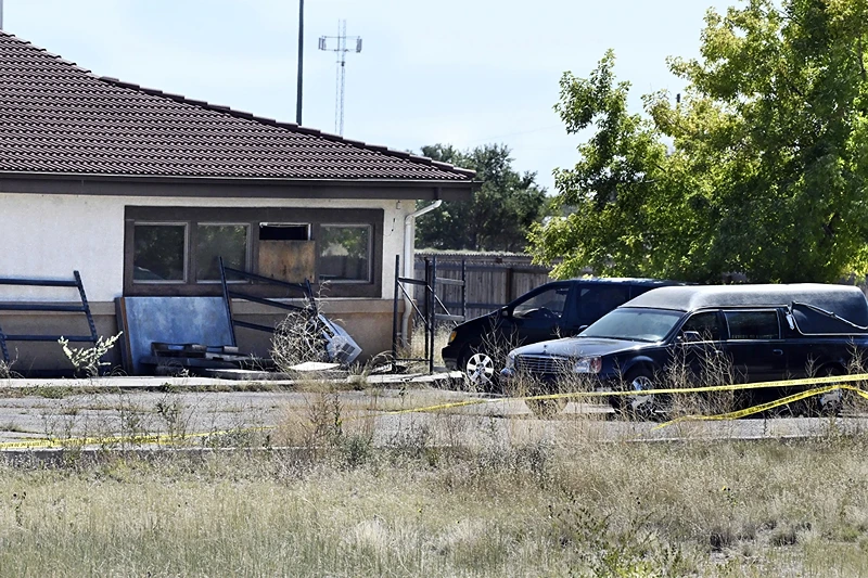 A hearse and debris can be seen at the rear of the Return to Nature Funeral Home in Penrose, Colo. Thursday, Oct. 5, 2023. Authorities said Thursday they were investigating the improper storage of human remains at a southern Colorado funeral home that performs "green" burials without embalming chemicals or metal caskets. (Jerilee Bennett/The Gazette via AP)