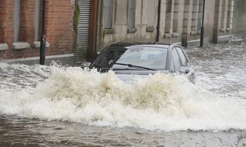 11 | A car drives through flood water on Canal Quay in Newry Town, Co Down, which has been swamped by floodwater as the city's canal burst its banks amid heavy rainfall, Wednesday Nov. 1, 2023. Dozens of businesses were engulfed in the floods, with widespread damage caused to buildings, furnishings and stock. (Brian Lawless/PA via AP)