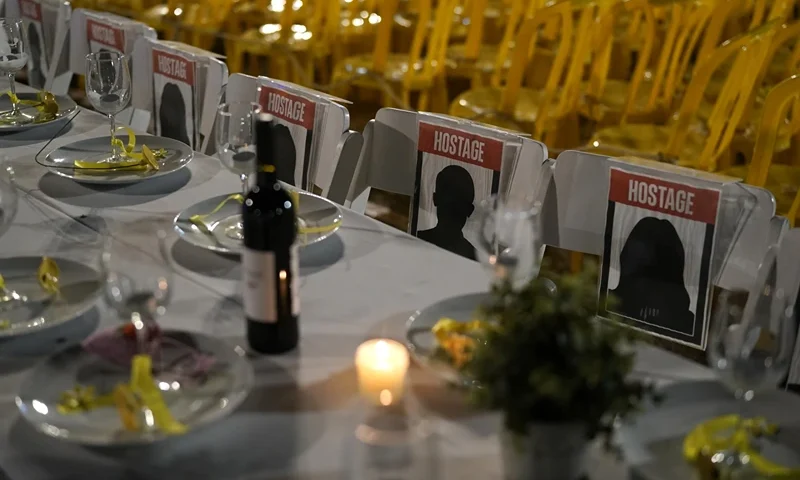 A table is set for hostages being held in the Gaza Strip, in a show of solidarity, in Tel Aviv, Israel Saturday, Nov. 25, 2023. Egyptian officials said Hamas was preparing to release 14 Israeli hostages Saturday for 42 Palestinian prisoners held by Israel. (AP Photo/Leo Correa)