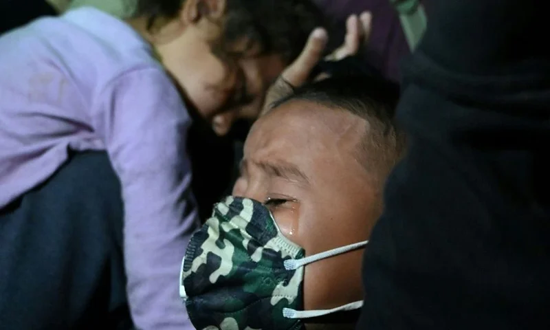 boy cries as Honduran migrants heading to the border with Guatemala, march in the municipality of El Florido, in the Honduran department of Copan, on January 15, 2021 on their way to the United States. - Some 3,000 people left Honduras on foot January 15 in the latest migrant caravan hoping to find a welcome, and a better life, in the US under President-elect Joe Biden. Seeking to escape poverty, unemployment, gang and drug violence and the aftermath of two devastating hurricanes, the migrants plan to walk thousands of kilometers through Central America. (Photo by Orlando SIERRA / AFP) (Photo by ORLANDO SIERRA/AFP via Getty Images)