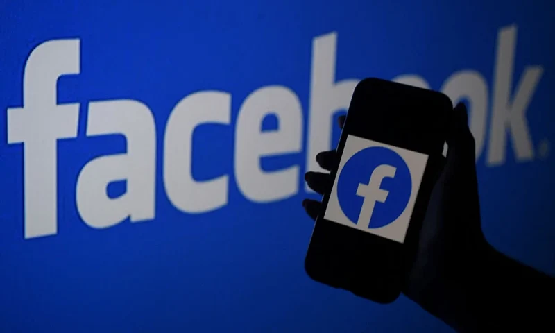 In this photo illustration, a smart phone screen displays the logo of Facebook on a Facebook website background, on April 7, 2021, in Arlington, Virginia - Facebook usage has held steady in the United States despite a string of controversies about the leading social network, even as younger users tap into rival platforms such as TikTok, a survey showed Wednesday. (Photo by OLIVIER DOULIERY / AFP) (Photo by OLIVIER DOULIERY/AFP via Getty Images)