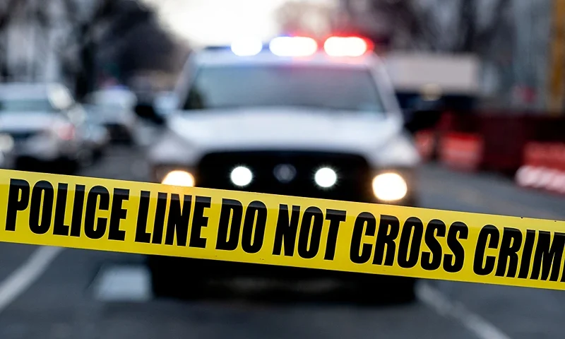 Police tape is seen in front of a police vehicle as Manuel Oliver displays a banner calling on government officials to prioritize gun violence prevention from a construction crane near the White House in Washington, DC, on February 14, 2022. - Olivers son Joaquin Oliver was killed in the Parkland School shooting four years ago today. (Photo by Stefani Reynolds / AFP) (Photo by STEFANI REYNOLDS/AFP via Getty Images)