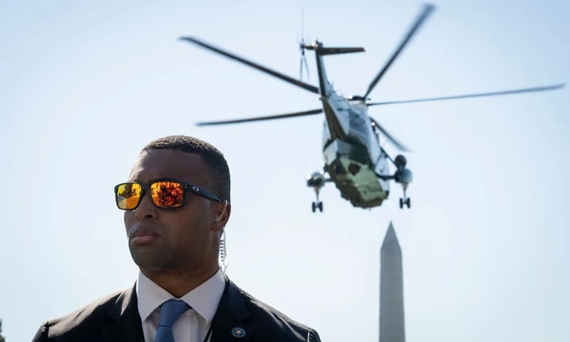 WASHINGTON, DC - OCTOBER 7: A member of the Secret Service stands watch as Marine One, with U.S. President Joe Biden onboard, lifts off from the South Lawn of the White House October 7, 2022 in Washington, DC. President Biden is traveling to Hagerstown, Maryland to tour a Volvo Group Trucks powertrain plant and deliver remarks on the economy. (Photo by Drew Angerer/Getty Images)