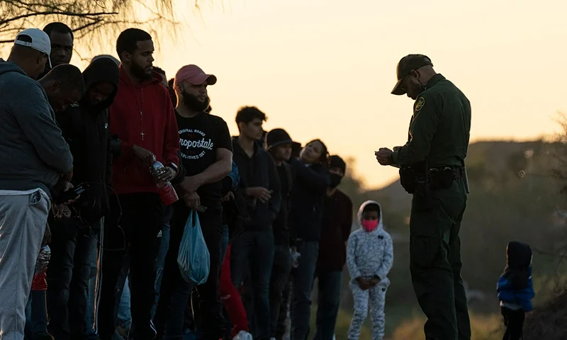 Migrants wait to be processed by Border Patrol agents in Eagle Pass, Texas on December 19, 2022. - The US Supreme Court halted December 19, 2022 the imminent removal of Title 42, a key policy used since the administration of president Donald Trump to block migrants at the southwest border, amid worries over a surge in undocumented immigrants. (Photo by VERONICA G. CARDENAS / AFP) (Photo by VERONICA G. CARDENAS/AFP via Getty Images)