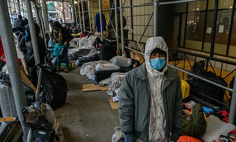 TOPSHOT - Migrants camp outside a hotel where they had previously been housed, as they resist efforts by the city to relocate them to a Brooklyn facility for asylum seekers, in the Hells Kitchen neighborhood of New York on January 31, 2023. - The Brooklyn facility is the city's fifth relief center amid a continued influx of asylum seekers, according to local media. (Photo by Ed JONES / AFP) (Photo by ED JONES/AFP via Getty Images)