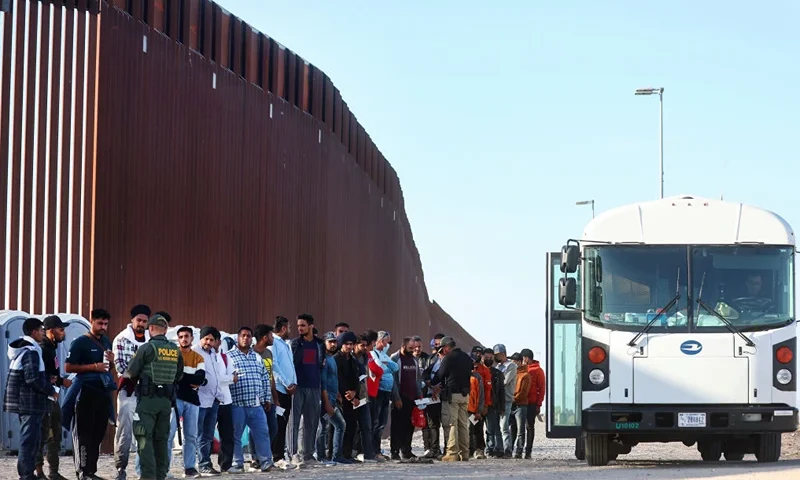 YUMA, ARIZONA - MAY 19: Immigrants wait to board a U.S. Border Patrol bus to be taken for processing after crossing the border from Mexico on May 19, 2022 in Yuma, Arizona. Title 42, the controversial pandemic-era border policy enacted by former President Trump, which cites COVID-19 as the reason to rapidly expel asylum seekers at the U.S. border, is set to officially expire on May 23rd. A federal judge in Louisiana is expected to deliver a ruling this week on whether the Biden administration can lift Title 42. (Photo by Mario Tama/Getty Images)