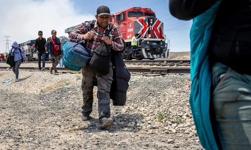 CIUDAD JUAREZ, MEXICO - MAY 10: Immigrants walk after disembarking from a freight train en route to the U.S.-Mexico border on May 10, 2023 near Ciudad Juarez, Mexico. Many migrants make the cheap yet dangerous ride north through Mexico on a network of freight trains, known as La Bestia (the Beast). A surge of immigrants is expected with the end of the U.S. government's Covid-era Title 42 policy, which for the past three years has allowed for the quick expulsion of irregular migrants entering the country. (Photo by John Moore/Getty Images)