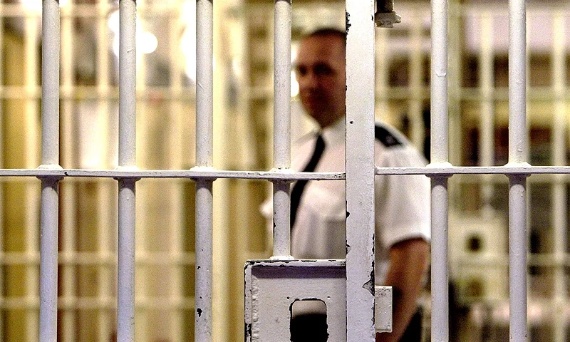 LONDON - MAY 19: (FILE PHOTO) A prison guard at HMP (Her Majesty's Prison) Pentonville stands behind a locked gate May 19, 2003 in London. A new report from the Prison Reform Trust (PRT) says overcrowding in Britain's prisons has been caused by tougher sentencing rather than an increase in crime. Since 1991, offenders of petty crimes are three times more likely to be imprisoned. (Photo by Ian Waldie/Getty Images)