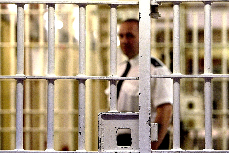 LONDON - MAY 19: (FILE PHOTO) A prison guard at HMP (Her Majesty's Prison) Pentonville stands behind a locked gate May 19, 2003 in London. A new report from the Prison Reform Trust (PRT) says overcrowding in Britain's prisons has been caused by tougher sentencing rather than an increase in crime. Since 1991, offenders of petty crimes are three times more likely to be imprisoned. (Photo by Ian Waldie/Getty Images)