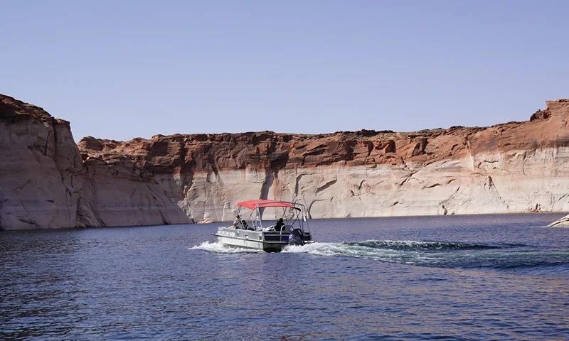 A boat makes its way past bathtub rings, showing the height of the water level in the past, on Lake Powell, Arizona on June 18, 2024. Lake Powell is the second largest reservoir in the US and can hold more than 23 million acre feet (2,837,024,700,000 hectare meter) of water. It's currently just under 39% full and still taking in water from what's left of Spring runoff. The drought conditions and population growth has been a continual stress on water throughout the southwest. (Photo by Bryan R. SMITH / AFP) (Photo by BRYAN R. SMITH/AFP via Getty Images)