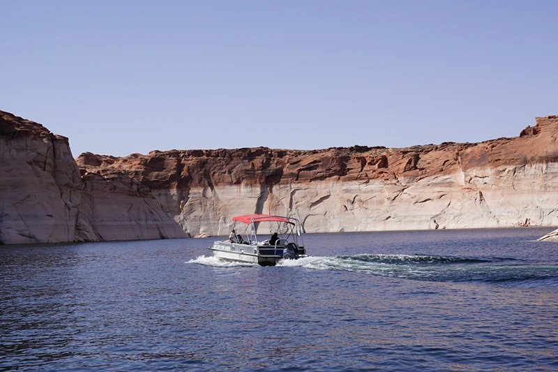 A boat makes its way past bathtub rings, showing the height of the water level in the past, on Lake Powell, Arizona on June 18, 2024. Lake Powell is the second largest reservoir in the US and can hold more than 23 million acre feet (2,837,024,700,000 hectare meter) of water. It's currently just under 39% full and still taking in water from what's left of Spring runoff. The drought conditions and population growth has been a continual stress on water throughout the southwest. (Photo by Bryan R. SMITH / AFP) (Photo by BRYAN R. SMITH/AFP via Getty Images)