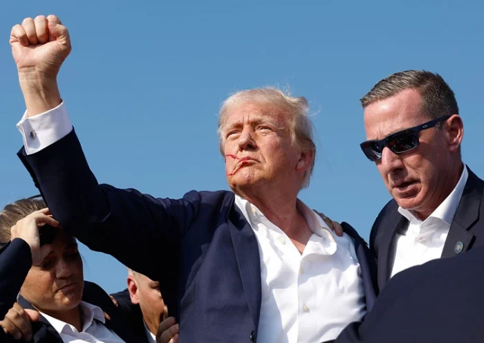 BUTLER, PENNSYLVANIA - JULY 13: Republican presidential candidate former President Donald Trump pumps his fist as he is rushed offstage during a rally on July 13, 2024 in Butler, Pennsylvania. Butler County district attorney Richard Goldinger said the shooter is dead after injuring former U.S. President Donald Trump, killing one audience member and injuring another in the shooting. (Photo by Anna Moneymaker/Getty Images)