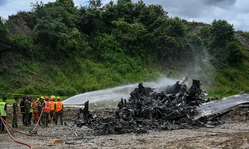 NEPAL-AVIATION-ACCIDENT Firefighters try to douse a fire that erupted in a Saurya Airlines' plane after it crashed during takeoff at the Tribhuvan International Airport in Kathmandu on July 24, 2024. A passenger plane crashed on takeoff in Kathmandu on July 24, with the pilot rescued from the flaming wreckage but all 18 others aboard killed, police in the Nepali capital told AFP. (Photo by PRAKASH MATHEMA / AFP) (Photo by PRAKASH MATHEMA/AFP via Getty Images)