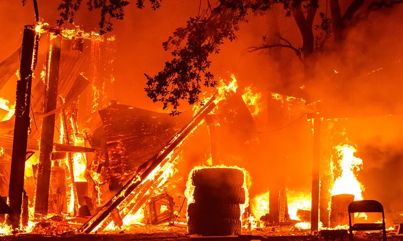 US-ENVIRONMENT-CLIMATE-FIRE A property is seen in flames as the Park fire continues to burn near Paynes Creek in unincorporated Tehama County, California on July 26, 2024. A huge, fast-moving and rapidly growing wildfire in northern California has forced more than 4,000 people to evacuate as firefighters battle gusty winds and perilously dry conditions, authorities said on July 26. (Photo by JOSH EDELSON / AFP) (Photo by JOSH EDELSON/AFP via Getty Images)