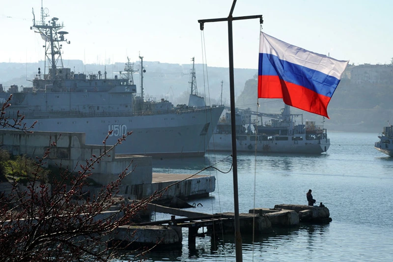 TOPSHOT - The Russian flag waves in front of the Ukrainian military ship the Slavutich moored in the bay of Sevastopol on March 22, 2014. About 200 pro-Russian protesters on March 22 stormed a Ukrainian air force base in western Ukraine, AFP correspondents saw. The unarmed crowd broke through to the base in the town of Novofedorivka and started smashing windows as Ukrainian servicemen barricaded themselves inside buildings and threw smoke bombs at the intruders from the roof. AFP PHOTO/ VIKTOR DRACHEV (Photo by VIKTOR DRACHEV / AFP) (Photo by VIKTOR DRACHEV/AFP via Getty Images)