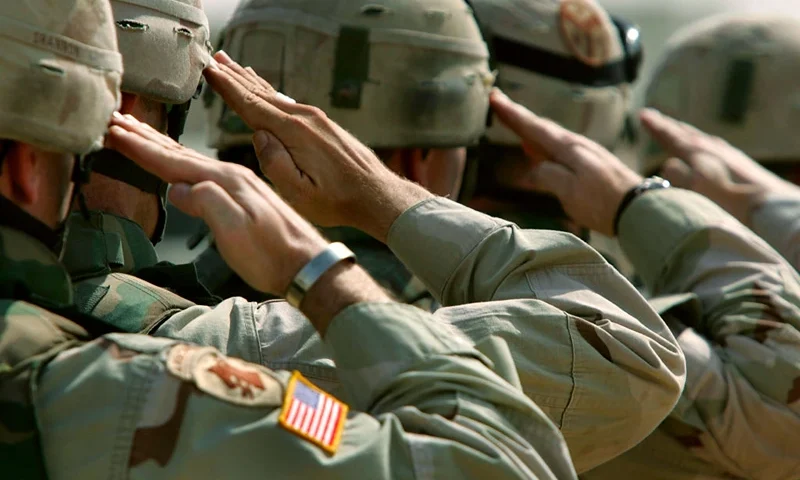 DUJAIL, IRAQ - OCTOBER 18: U.S. Army soldiers salute during a memorial service for Sgt. Robert Tucker at a military base October 18, 2005 in Dujail, Iraq. Tucker, 20, from Cookeville, Tennessee, was killed by insurgents when a roadside bomb blew up his armored vehicle on October 13 near Dujail, just two weeks before the end of his 10-month deployment in Iraq. He was assigned to K-Troop, of the 278th Armored Cavalry Regiment, which patrols the area around Dujail. Saddam Hussein is scheduled to go on trial on October 19, for the death of 143 people from Dujail who he allegedly ordered killed in 1985 in revenge for an assassination attempt. (Photo by John Moore/Getty Images)