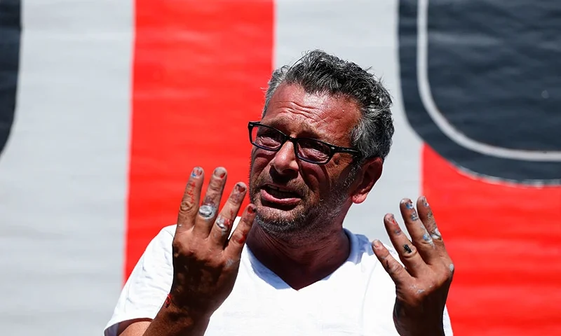 New York artist Scott LoBaido speaks after he unveils a 'Patriotic Lawn T' in support 2016 Republican presidential nominee Donald Trump in the area of Castleton Corners on Staten Island, New York on August 9, 2016. LoBaido's 12-foot-high "T" was destroyed fire set by an unidentified arsonist on August 7. Lobaido created a brand new statue that stands in the yard belonging to Trump supporter Sam Pirozzolo. / AFP / KENA BETANCUR (Photo credit should read KENA BETANCUR/AFP via Getty Images)