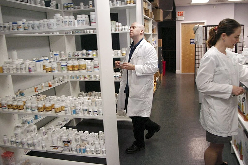 GLENSIDE, PA - SEPTEMBER 7:  Pharmacist Howard Brooker(C) and his wife Pam Harvey (R) fill a prescription at Adams Discount Pharmacy September 7, 2006 in Glenside, Pennsylvania. Adams offers generic drugs for forty to seventy five percent cheaper than the brand name manufacturer's cost. They are able to charge low prices by not dealing with insurance companies. (Photo by William Thomas Cain/Getty Images)