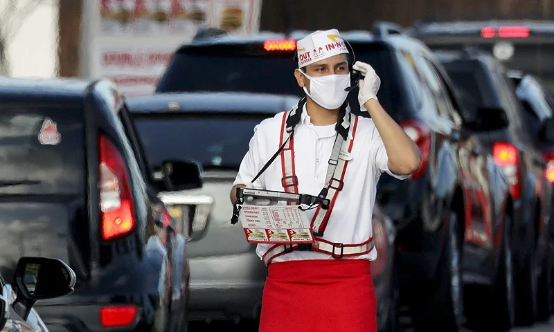 LOS ANGELES, CALIFORNIA - JULY 01: A worker wears a face covering while taking orders from motorists in the drive-through lane at an In-N-Out Burger restaurant amid the COVID-19 pandemic on July 1, 2020 in Los Angeles, California. California Governor Gavin Newsom ordered indoor dining restaurants to close again today in Los Angeles County and 18 other counties for at least three weeks amid a surge in new coronavirus cases. Restaurants may remain open for takeout and drive-through orders. (Photo by Mario Tama/Getty Images)