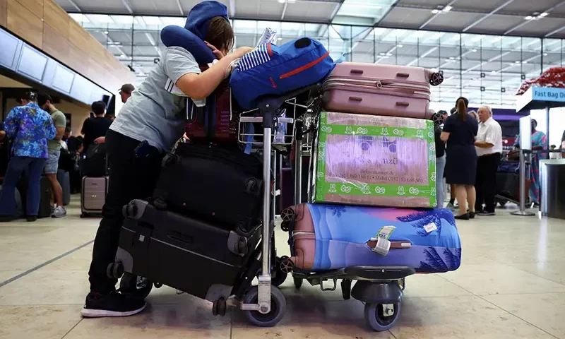 A person with luggage waits at BER airport following a global IT outage, in Berlin, Germany, July, 19, 2024. REUTERS/Nadja Wohlleben