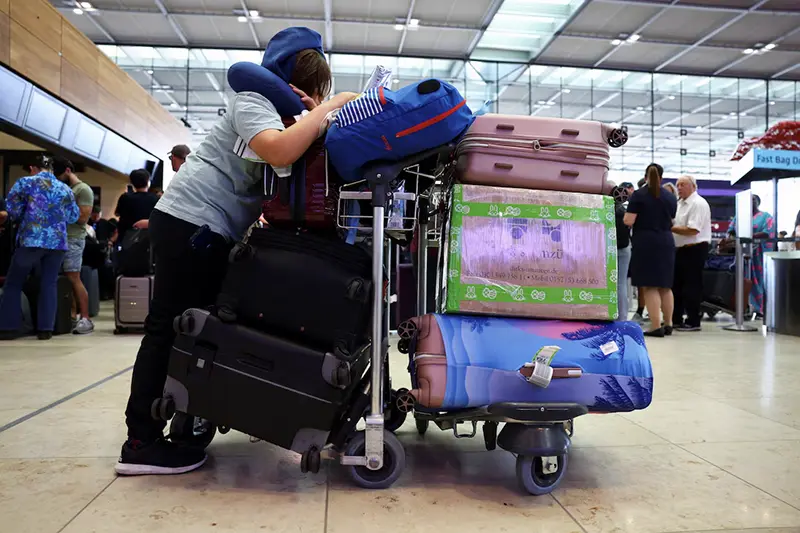 A person with luggage waits at BER airport following a global IT outage, in Berlin, Germany, July, 19, 2024. REUTERS/Nadja Wohlleben