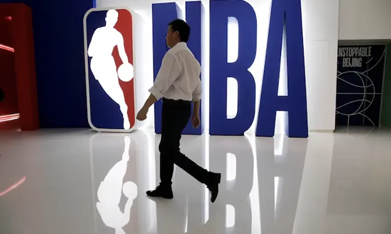 A man walks past an NBA logo at an NBA exhibition in Beijing, China October 8, 2019. REUTERS/Jason Lee/File Photo