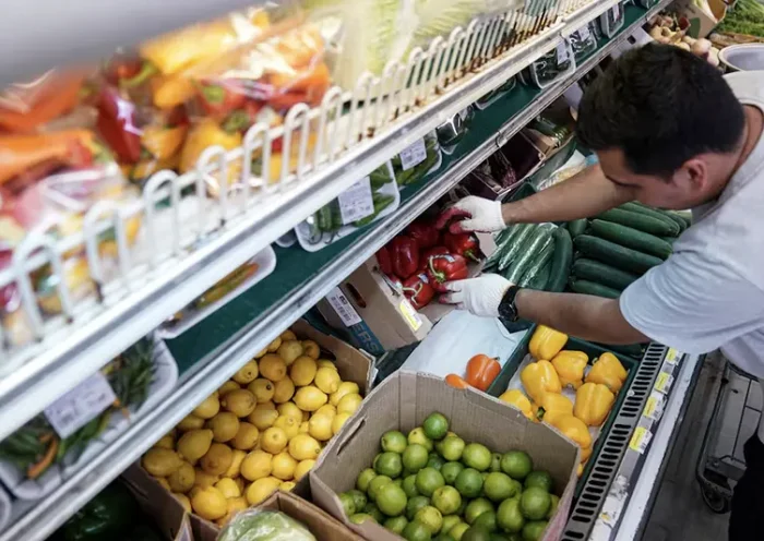 A man arranges produce at Best World Supermarket in the Mount Pleasant neighborhood of Washington, D.C., U.S., August 19, 2022. REUTERS/Sarah Silbiger/File Photo