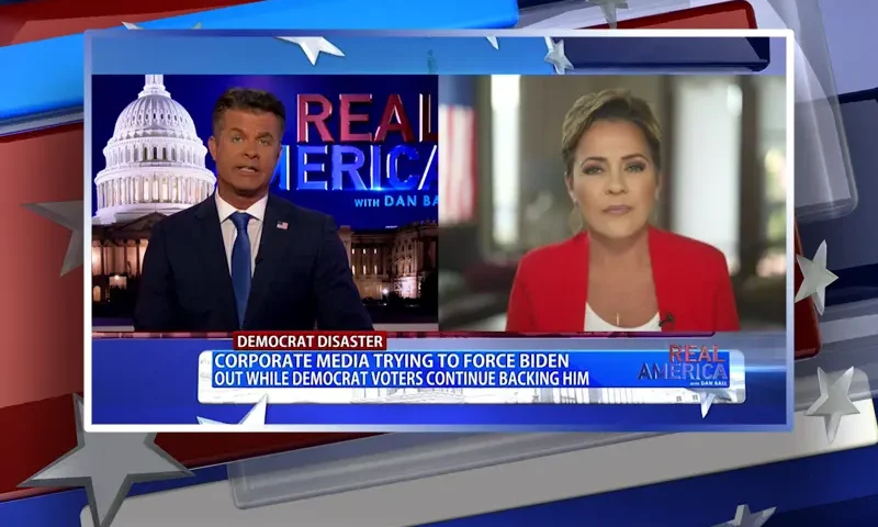 Video still from Real America on One America News Network showing a split screen of the host on the left side, and on the right side is the guest, Kari Lake.