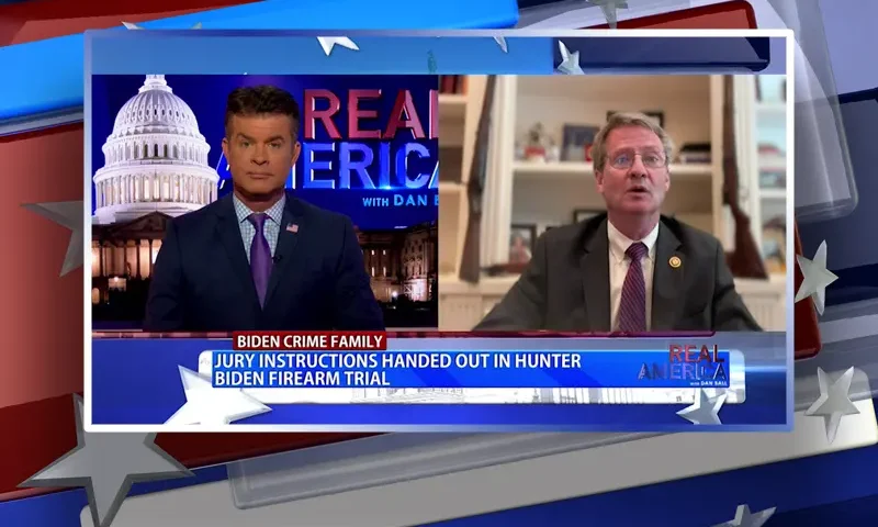 Video still from Real America on One America News Network showing a split screen of the host on the left side, and on the right side is the guest, Rep. Tim Burchett.